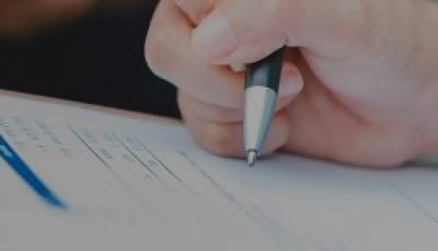 Ręka trzymająca długopis wypełnia formularz