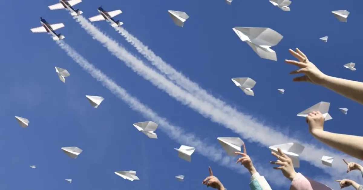 Papierowe samoloty na tle nieba.