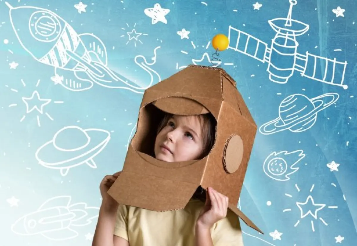 Dziecko przebrane w karton udający rakietę kosmiczną.