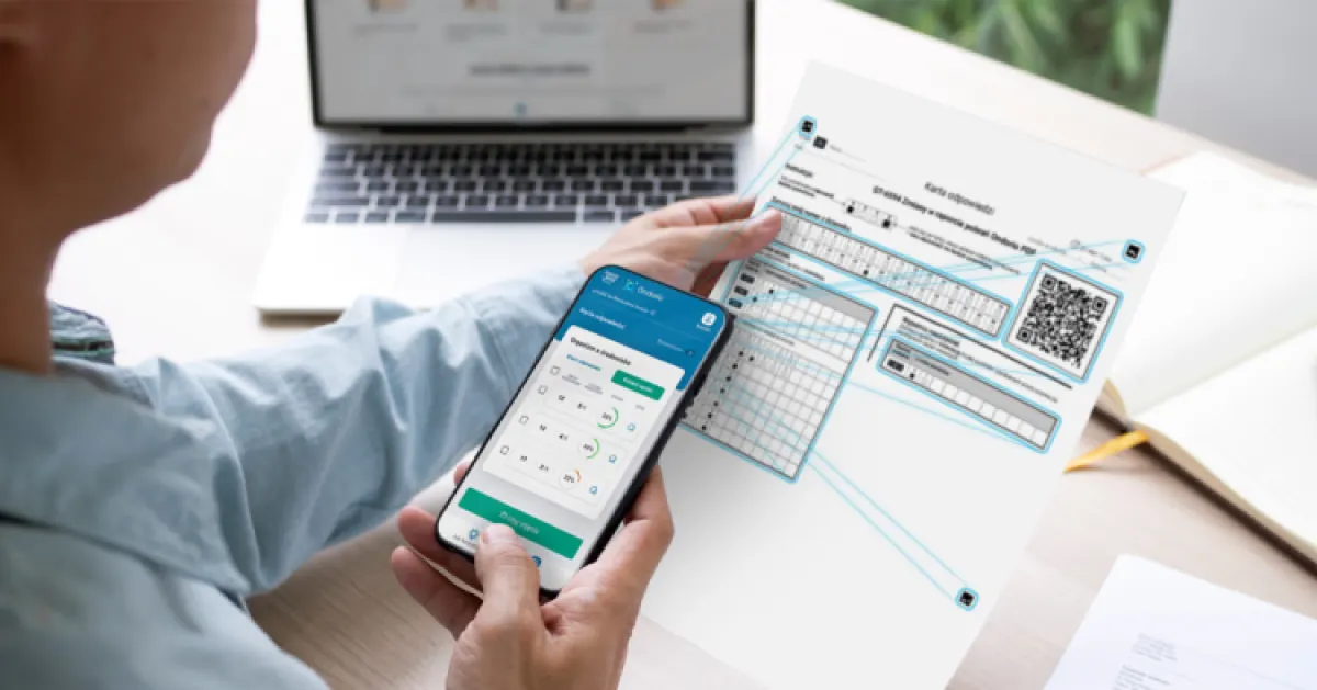 Nauczyciel ze smartfonem w ręce sprawdzający prace uczniów.