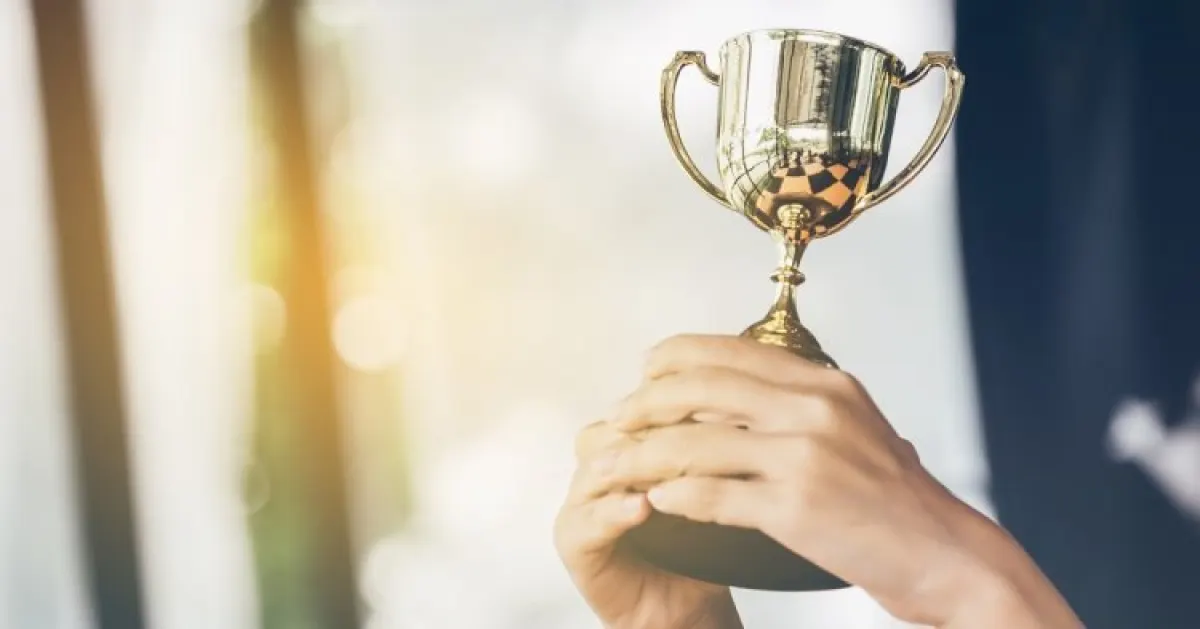 Ręce trzymające puchar.