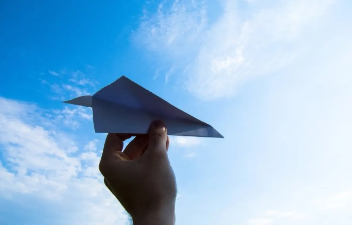 Papierowy samolot na tle nieba.