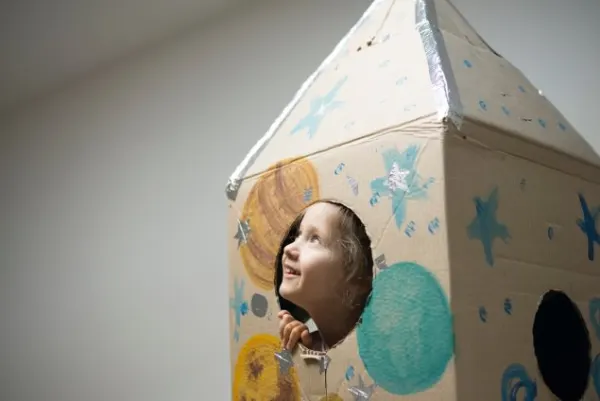 Dziewczynka w kartonie przypominającym zamek.