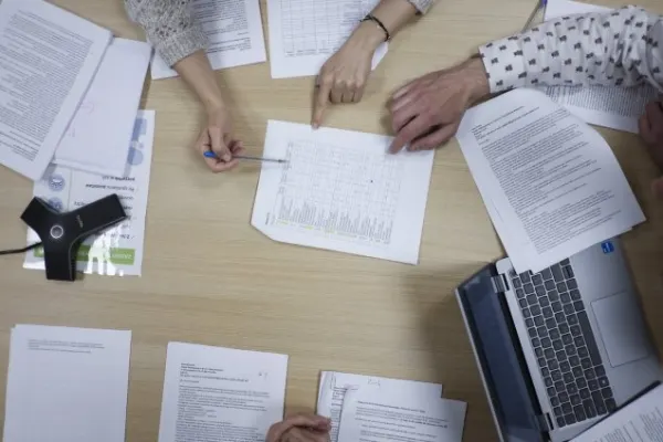 Dłonie trzymające kartki papieru.